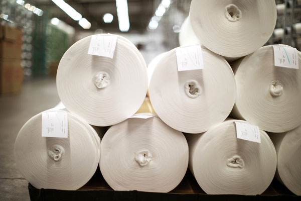 Rolls of white fabric for knit manufacturing